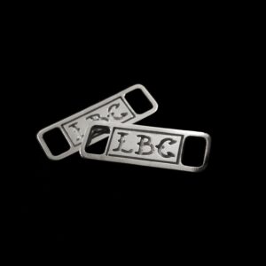 Image of two 925 silver shoelace charms that spell "LBC" on both separately.